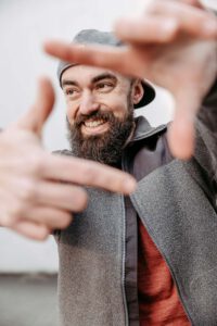 Marvin Rust Fotograf für Industrie und Handwerk bildet einen Rahmen mit seinen Händen und lächelt zur Seite