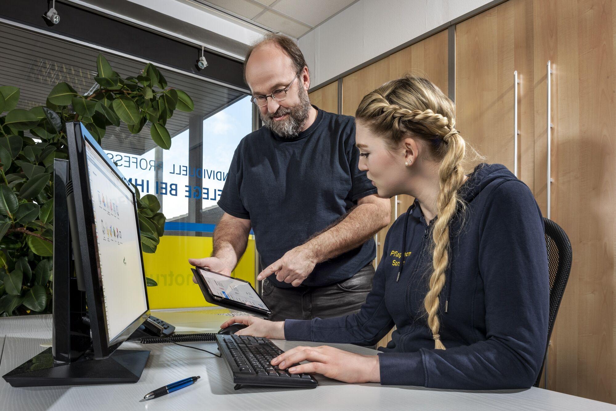 Businessfotografie: zwei Mitarbeitende besprechen etwas am Bildschirm im Büro