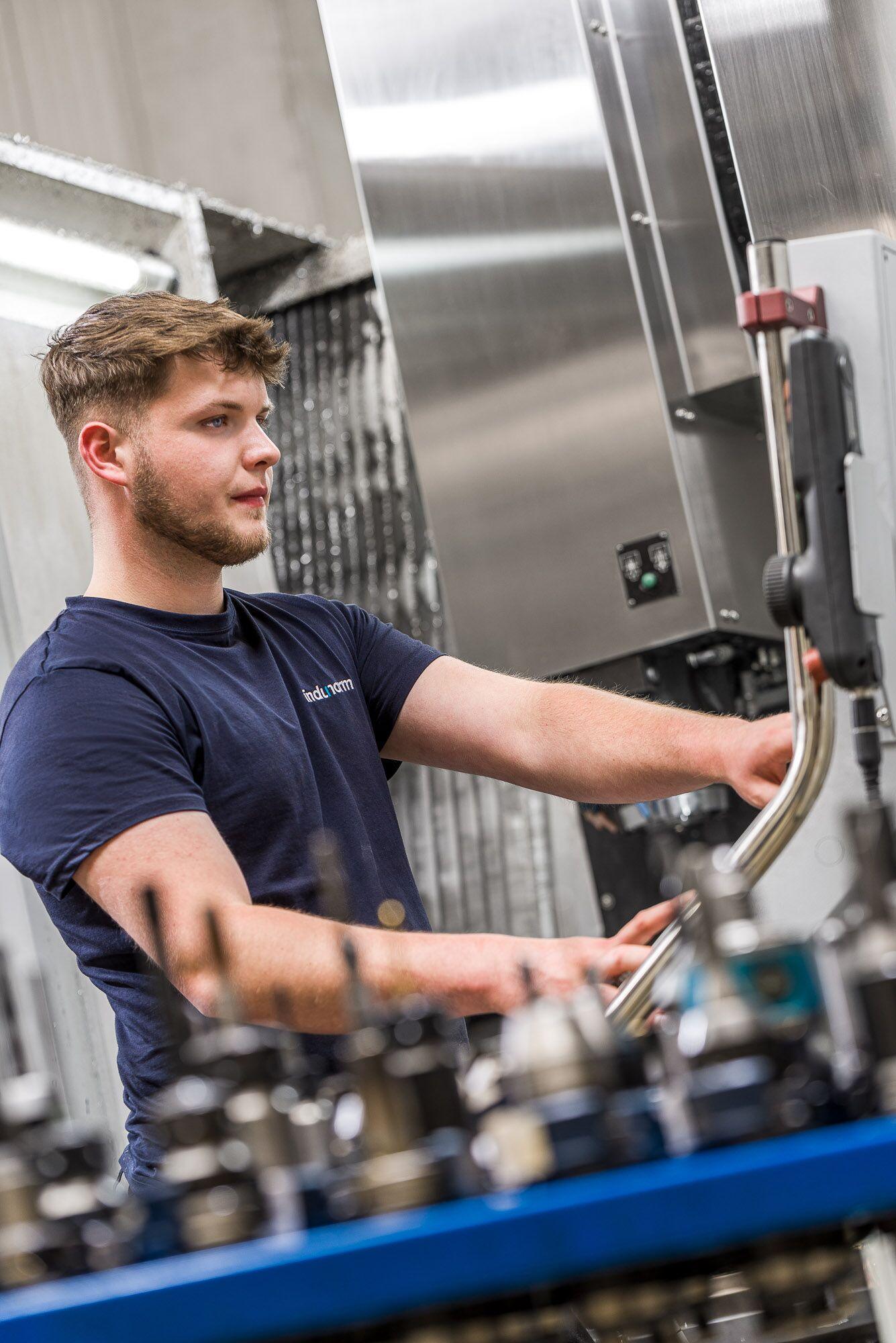 Industriefotografie: Maschinenbediener arbeitet konzentriert an einer Produktionsanlage