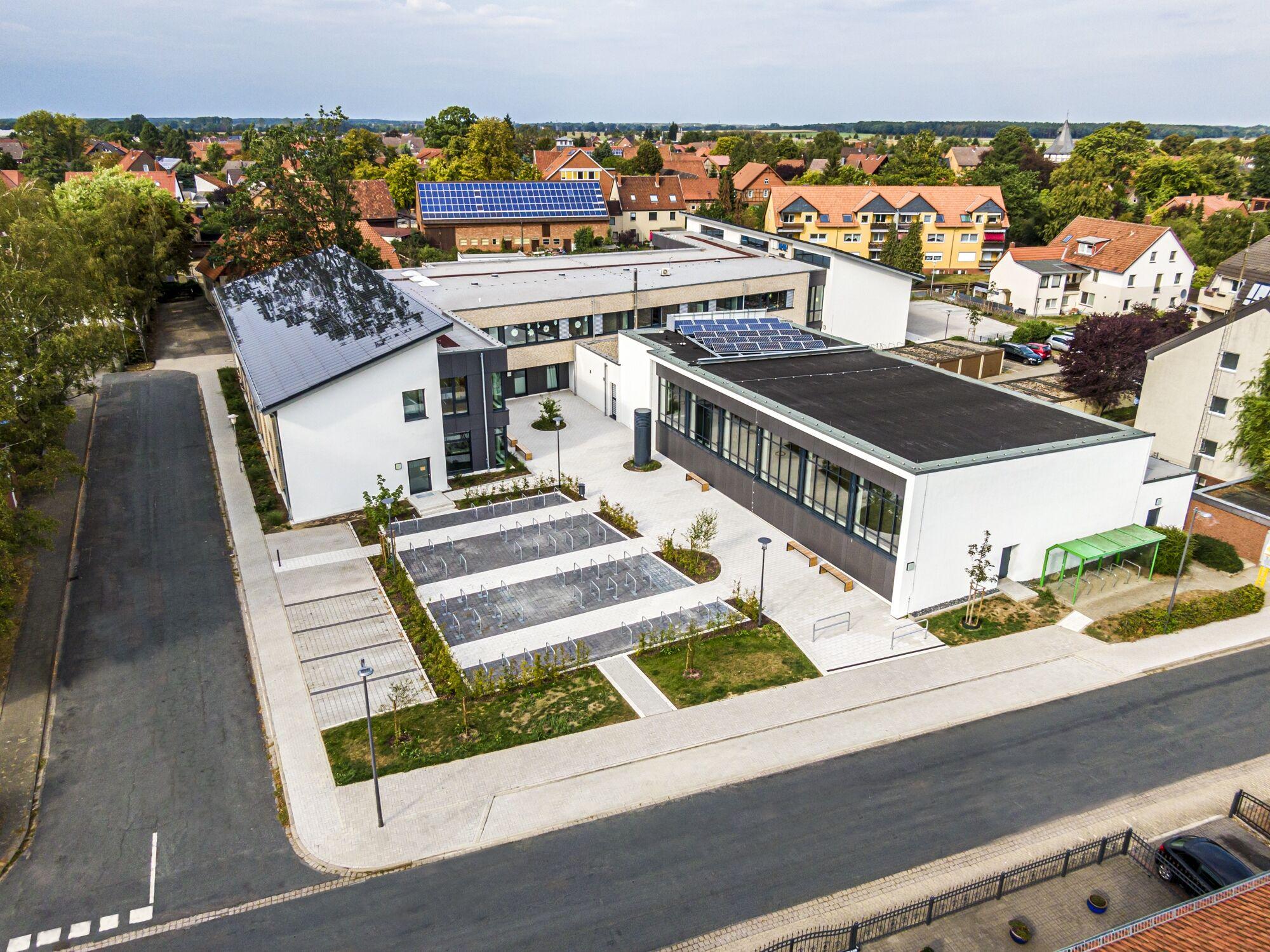 Luftaufnahme per Drohne: Gebäudekomplex mit Solardach in einem Ortskern