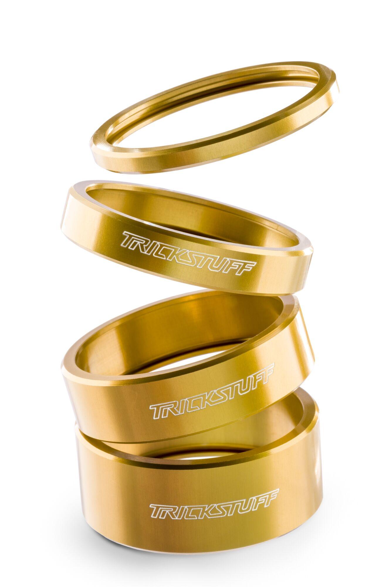 Produktfotografie: gestapelte goldene Spacer mit trickstuff-Logo freigestellt auf Weiß
