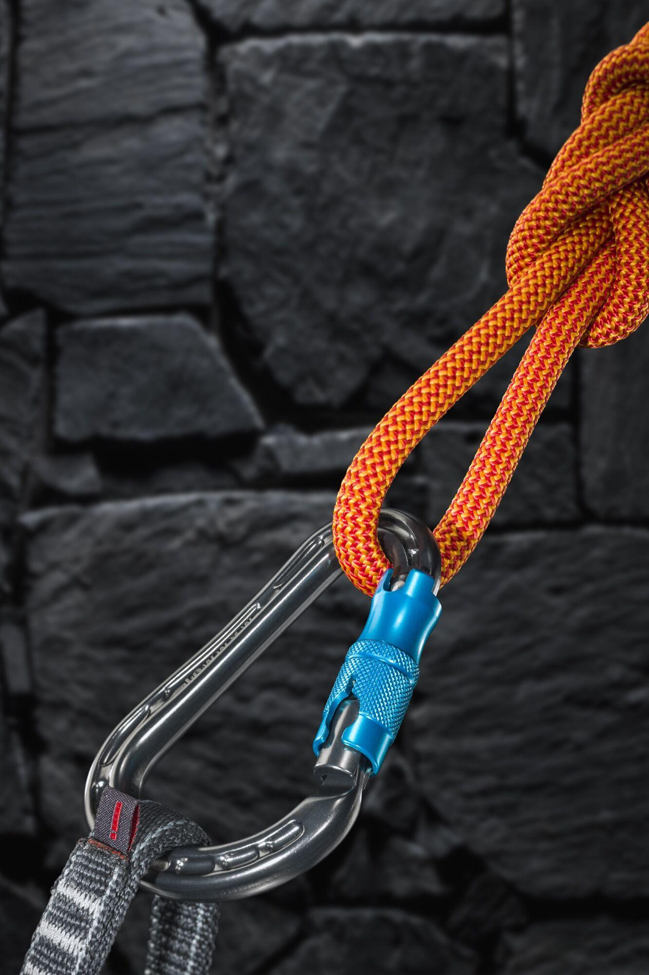 Produktfotografie: blauer Karabiner mit orangem Kletterseil vor Schieferwand