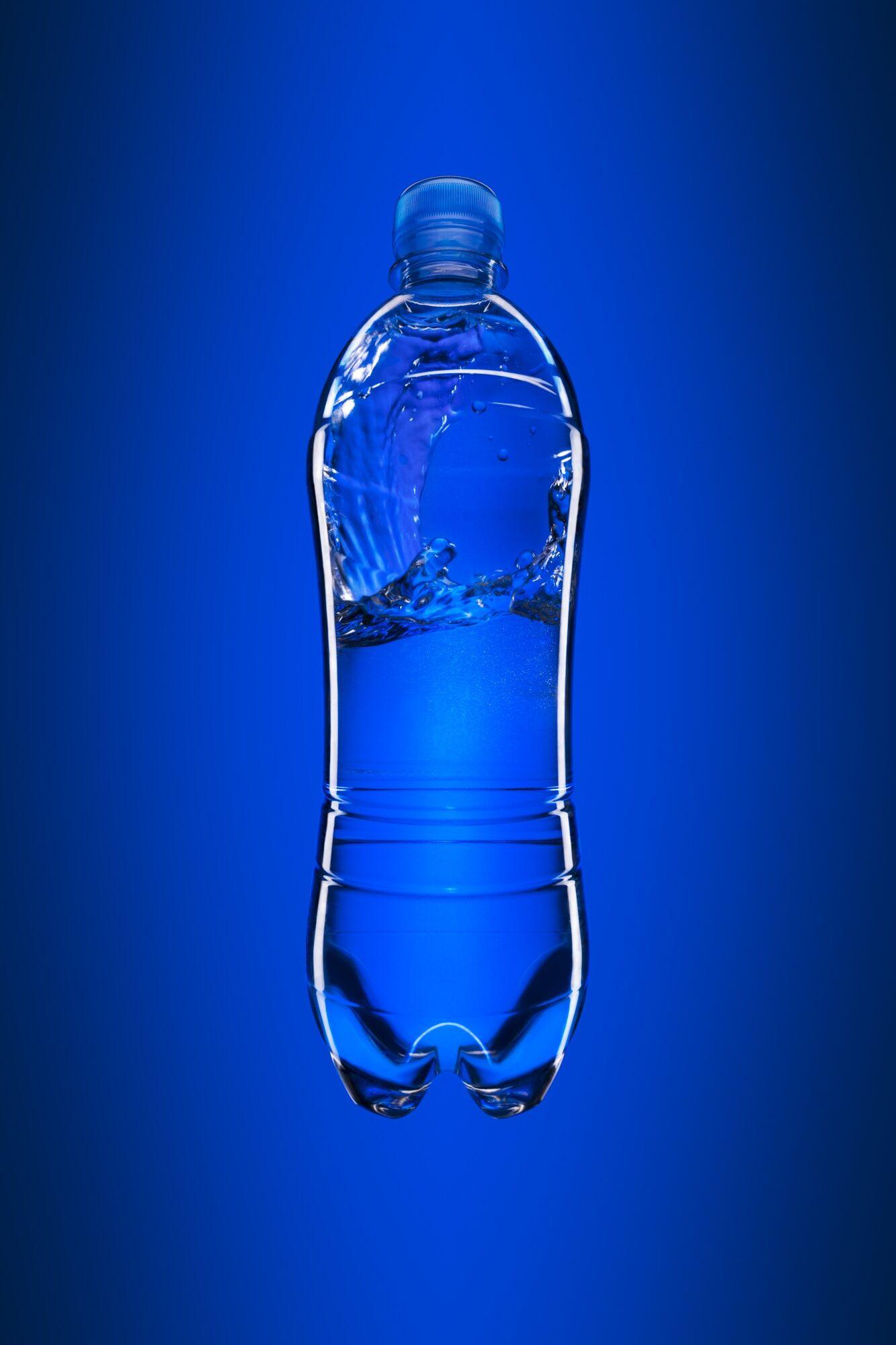 Produktfotografie: Wasserflasche mit Spritzwasser vor blauem Hintergrund