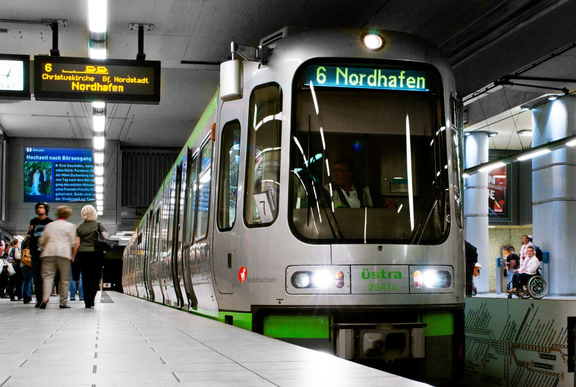 Reportagefotografie: Stadtbahn fährt in eine unterirdische Station mit Fahrgästen ein